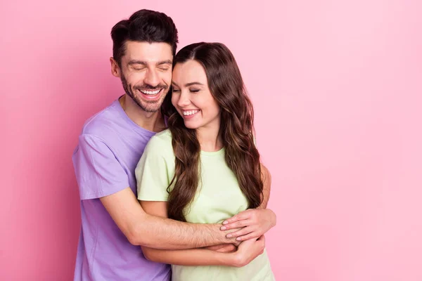 Retrato de atractiva pareja alegre tierna y soñadora abrazando disfrutando aislado sobre fondo de color pastel rosa — Foto de Stock