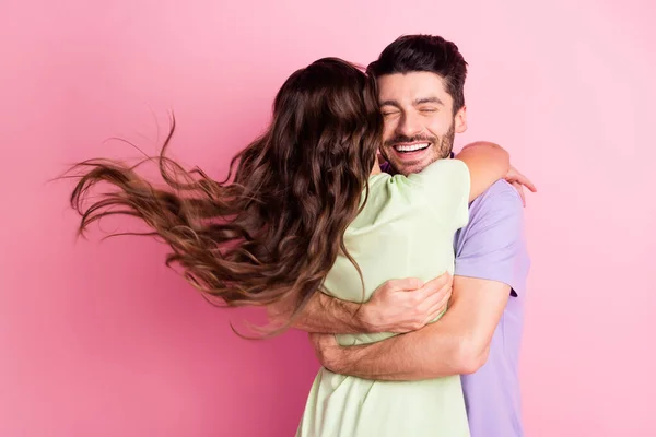 Retrato de pareja alegre cariñosa y atractiva abrazando el viento soplando pelo aislado sobre fondo de color pastel rosa — Foto de Stock