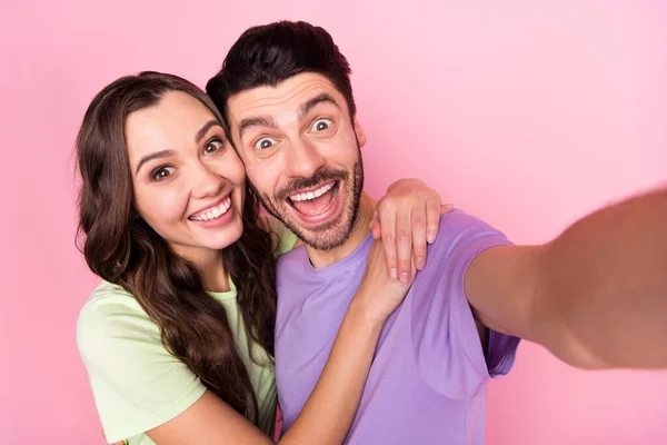 Auto-retrato de atraente funky infantil casal alegre espantado abraçando se divertir isolado sobre fundo cor pastel rosa — Fotografia de Stock