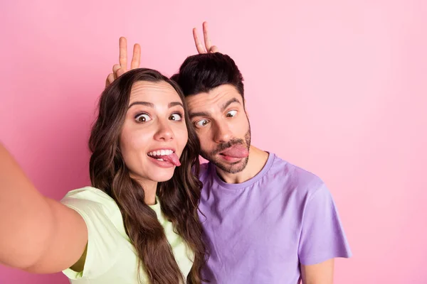 Auto-retrato de amigos bonitos amizade moderno casal louco abraço mostrando v-sinal chifre sorrir isolado sobre rosa cor pastel fundo — Fotografia de Stock