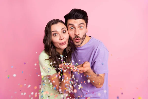 Retrato de casal alegre engraçado atraente abraçando soprando decoração humor festal isolado sobre cor pastel rosa fundo — Fotografia de Stock