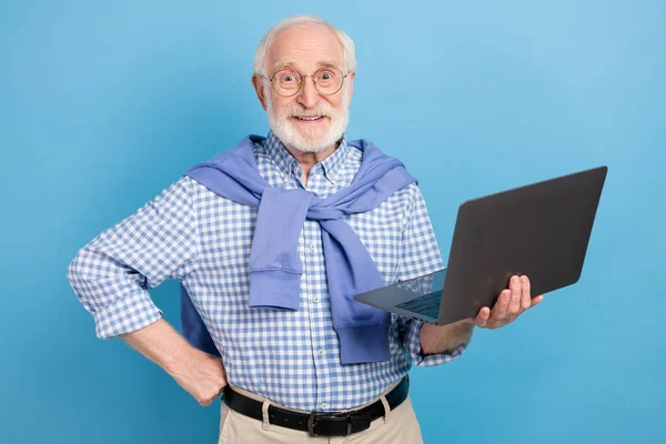 Foto de optimista viejo gris peinado hombre celebrar portátil llevar gafas camisa azul aislado sobre fondo de color pastel — Foto de Stock