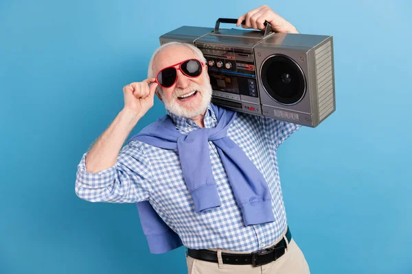 Foto van optimistisch oud grijs kapsel man houden boom-box slijtage bril blauw shirt geïsoleerd op kleur achtergrond — Stockfoto