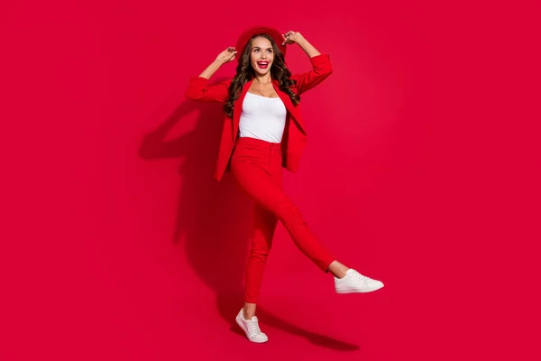 空想魅力的な若い女性の写真スーツジャケット腕キャップ笑顔歩く空のスペース孤立した赤の色の背景 — ストック写真
