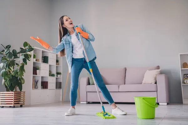 Foto em tamanho completo de morena millennial bonita senhora lavar chão cantar desgaste jeans camisa sapatos luvas em casa sozinho — Fotografia de Stock