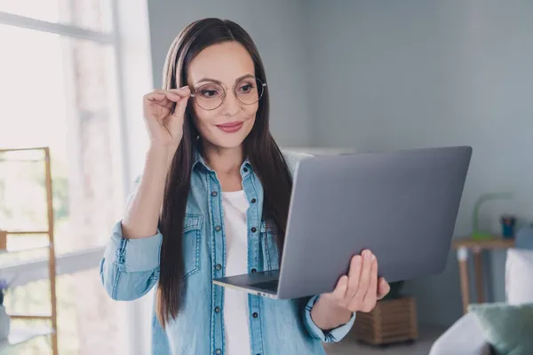 Foto van vrolijke positieve gelukkig volwassen vrouw kijken computer glimlach lees e-mail binnen huis — Stockfoto