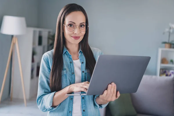 Foto van positieve gelukkig volwassen vrouw houd handen computer externe werknemer glimlach binnen huis — Stockfoto