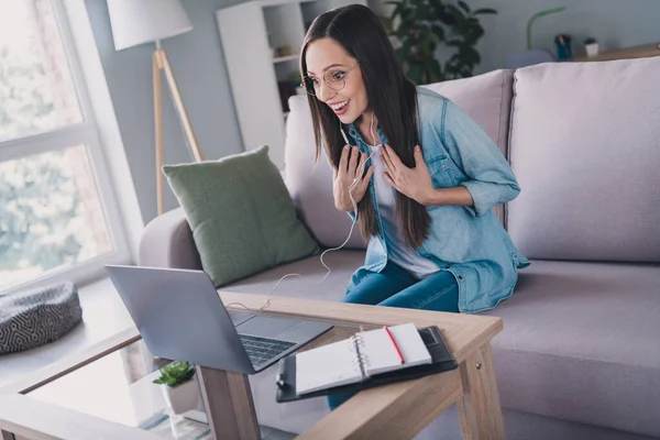 Retrato de mujer alegre asombrada atractiva sentada en diván usando el ordenador portátil que llama el hablar que se divierte en el interior de casa — Foto de Stock