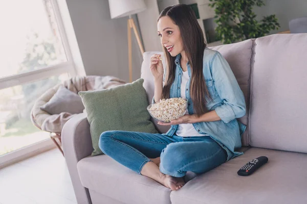 Профиль вид сбоку портрет довольно веселой женщины, сидящей смотреть сериал едят кукурузу отдыха времяпрепровождение дома в помещении — стоковое фото