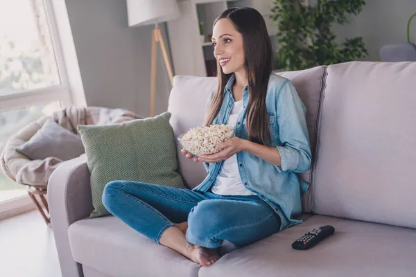 Profilo vista laterale ritratto di attraente donna allegra seduta sul divano guardare serie mangiare mais a casa al chiuso — Foto Stock