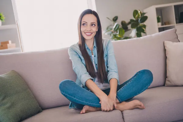 Portret van aantrekkelijke nieuwsgierig vrij vrolijke langharige vrouw zittend op divan verblijf veilig goed humeur thuis binnen — Stockfoto