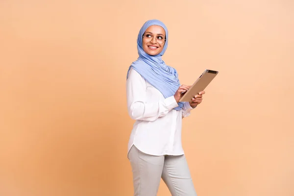 Perfil foto do jovem árabe moderno senhora olhar promo escrever tablet desgaste lenço camisa óculos calças isoladas no fundo bege — Fotografia de Stock