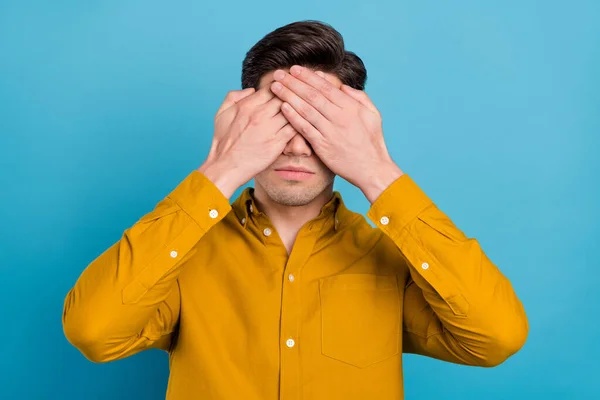 Foto von schweren unglücklichen jungen Mann tragen gelbes Hemd Arme bedecken Augen mit Kopfschmerzen isoliert blaue Farbe Hintergrund — Stockfoto