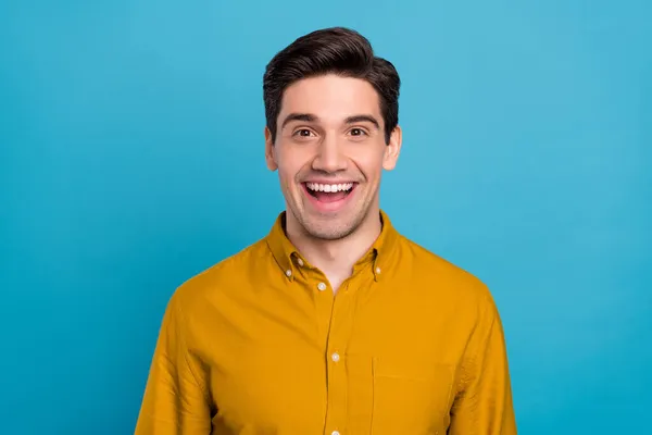 Foto av glada funky ung kille klädd gul skjorta ler öppen mun isolerad blå färg bakgrund — Stockfoto