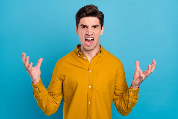 Foto di arrabbiato furioso ragazzo urlare bocca aperta alzare le mani indossare camicia gialla isolato colore blu sfondo — Foto Stock