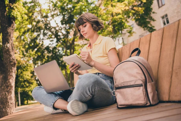 Полное фото тела молодой серьезной женщины написать записку держать ноутбук сидеть скамейка городской образ жизни за пределами города — стоковое фото