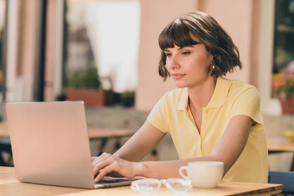 Portré vonzó fókuszált lány segítségével laptop ül a kávézóban dolgozik távolról a friss levegő szabadban — Stock Fotó