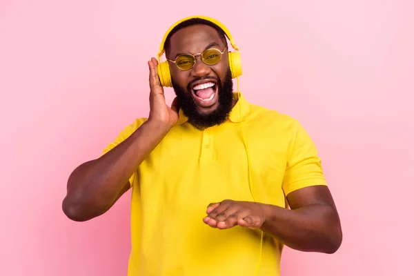 Fotografie afro americký šťastný blázen muž nosit sluchátka dj music milenec vychutnat píseň izolované na růžové barevné pozadí — Stock fotografie