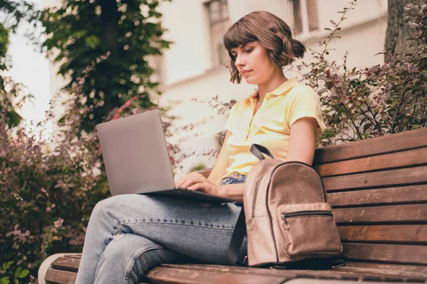 Фото серьезной очаровательной целеустремленной молодой женщины держать за руки компьютер сидеть скамейку на открытом воздухе города — стоковое фото