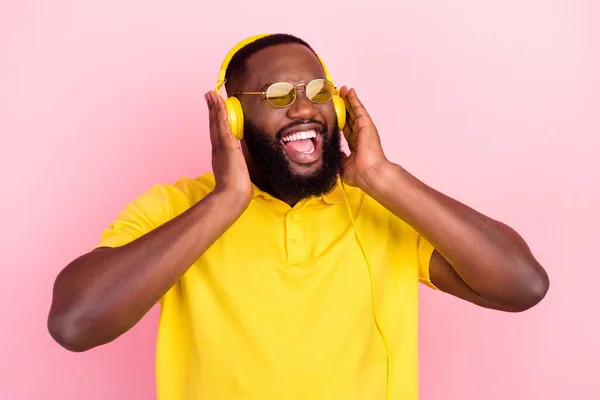 Foto de afro americano alegre loco hombre disfrutar de música lista de reproducción fresco estado de ánimo aislado sobre fondo de color rosa —  Fotos de Stock