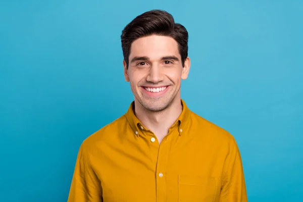 Zdjęcie wesoły pozytywny przystojny facet zębaty promień uśmiech nosić żółty koszula odizolowany niebieski kolor tło — Zdjęcie stockowe