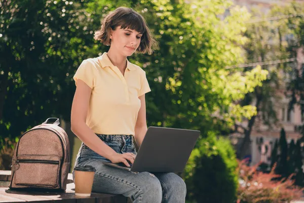Portrét atraktivní zaostřené dívky sedící na lavičce pomocí notebooku psaní e-mailového projektu na čerstvém vzduchu venku — Stock fotografie