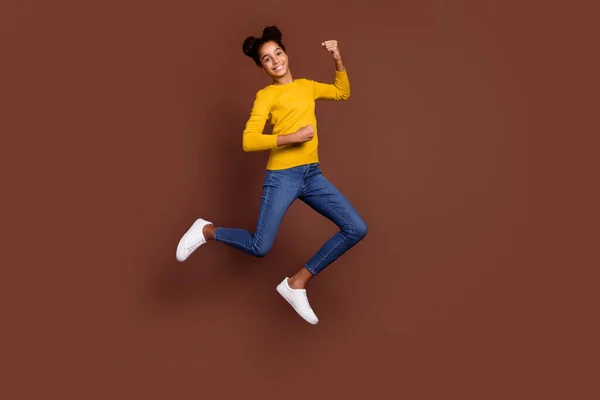 Full size foto di stile piccola ragazza salto indossare camicia jeans scarpe da ginnastica isolato su sfondo di colore marrone — Foto Stock