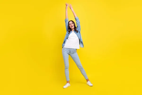 Photo of funny adorable young lady wear jeans shirt smiling dancing isolated yellow color background — Stock Photo, Image