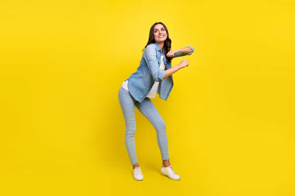 Foto av bedårande rolig ung dam bära jeans skjorta ler dans isolerad gul färg bakgrund — Stockfoto