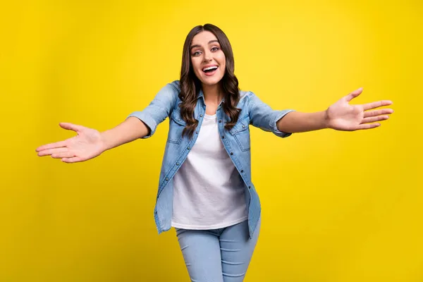 Foto di giocoso amichevole giovane donna vestita camicia di jeans che vi invita abbracciando sorridente isolato colore giallo sfondo — Foto Stock