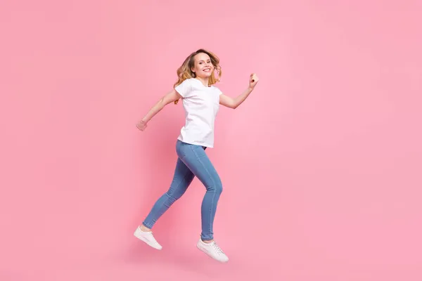 Pełna długość ciała rozmiar zdjęcia dziewczyna noszenie stylowe ubrania skoki działa na sprzedaż odizolowane pastelowy różowy kolor tło — Zdjęcie stockowe