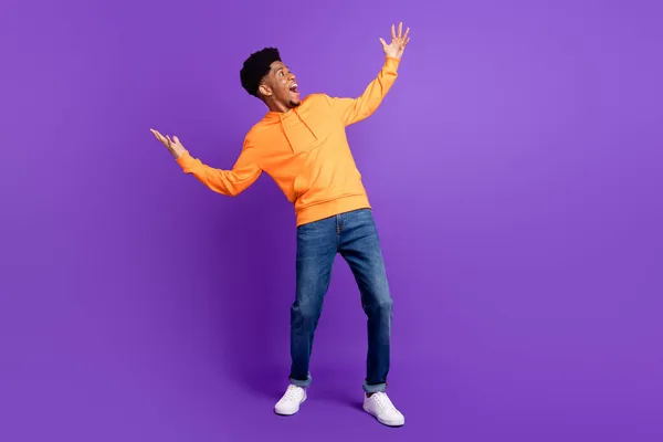 Celotělová fotografie pozitivní mladé tmavé kůže muž vypadat prázdný prostor ruce ohromen izolované na fialové barvy pozadí — Stock fotografie