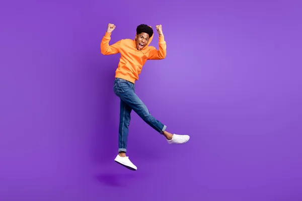 Foto de cuerpo entero del joven afro americano feliz saltar campeón ganador aislado sobre fondo de color púrpura — Foto de Stock