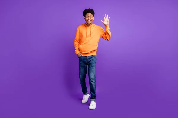 Full tělo fotografie mladého černocha šťastný pozitivní úsměv mává rukou ahoj hi izolované přes fialové barvy pozadí — Stock fotografie