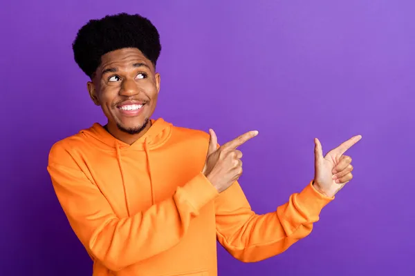 Фото молодого веселого афро-хлопця щаслива позитивна посмішка дивитися точкові пальці порожній простір поради ізольовані на фіолетовому кольоровому фоні — стокове фото