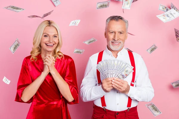Portret van twee mooie knappe trendy vrolijke echtgenoten gooien geld krediet lening geïsoleerd over roze pastel kleur achtergrond — Stockfoto