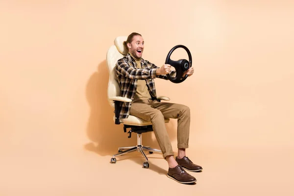 Full storlek profil sida foto av ung man rida auto fordon spela videospel isolerad över beige färg bakgrund — Stockfoto