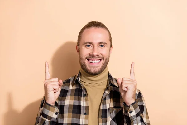 Fénykép a fiatal férfi jelzi ujjak üres tér promoter promo hirdetni elszigetelt bézs színű háttér — Stock Fotó