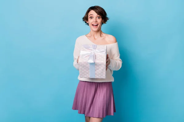 Foto portrét vzrušené dívky držení zabalené dárek box izolované na pastelové modré barevné pozadí — Stock fotografie