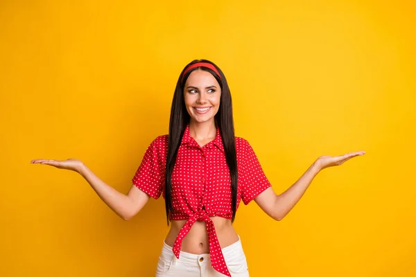 Πορτρέτο της ελκυστικό χαρούμενο κορίτσι κρατώντας στις παλάμες δύο παραλλαγές χώρο αντίγραφο vs διαφήμιση απομονώνονται σε φωτεινό κίτρινο χρώμα φόντο — Φωτογραφία Αρχείου