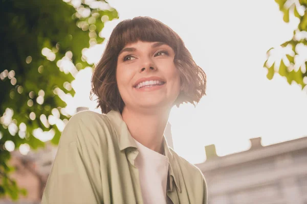 Фото довольно блестящей юной леди в зеленой рубашке рюкзак прогулки улыбаясь на открытом воздухе городского парка — стоковое фото