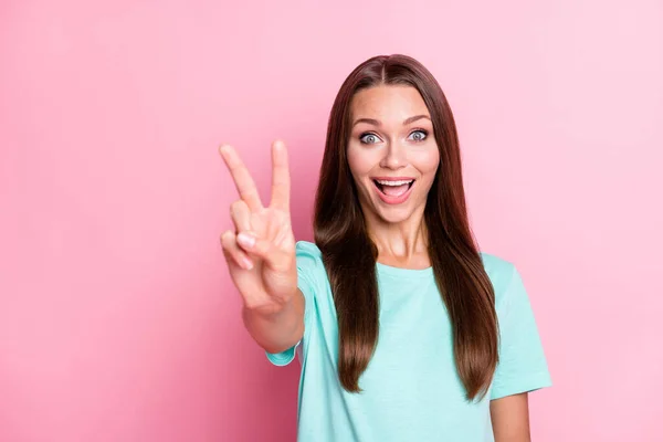 Foto retrato de alegre chica feliz mostrando gesto de signo v sonriendo aislado sobre fondo de color rosa pastel con copyspace — Foto de Stock