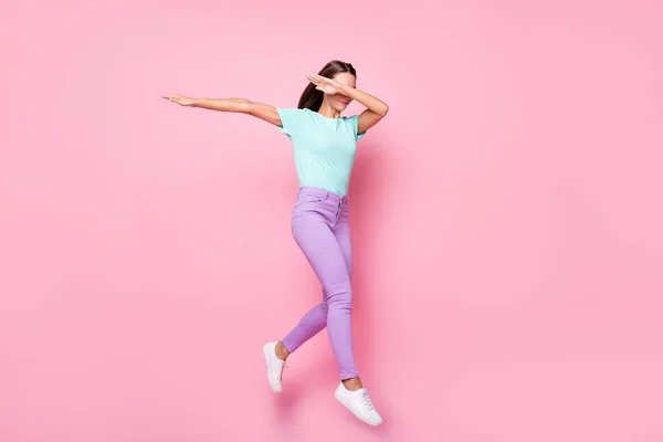 Foto de tamaño completo de joven atractiva encantadora encantadora mujer salto de baile cara estrecha con la mano aislada en el fondo de color rosa — Foto de Stock