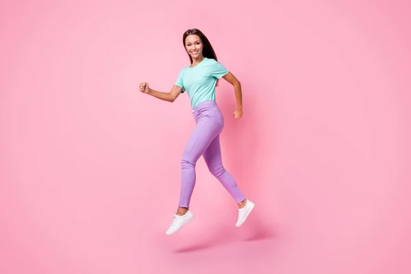 Foto lateral de perfil de tamaño completo de la joven atractiva hermosa mujer sonriente salto usar pantalones púrpura aislado en el fondo de color rosa —  Fotos de Stock