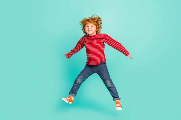 Plná velikost fotografie funky malý chlapec skok nosit košili džíny tenisky izolované na modrém pozadí — Stock fotografie
