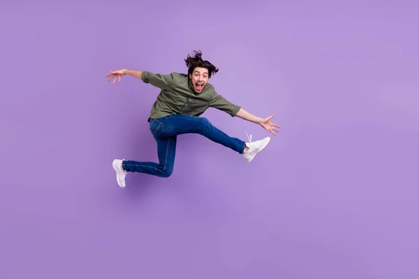 フルサイズ写真のクレイジー正幸せな若い男ジャンパーアップ実行空のスペースクール隔離上の紫の色の背景 — ストック写真