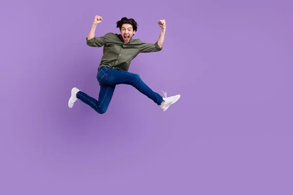 Corpo inteiro foto de louco alegre jovem feliz saltar para cima cool runn vencedor isolado no fundo cor violeta — Fotografia de Stock