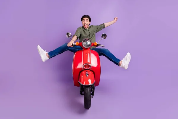Ganzkörperfoto von coolen fröhlichen verrückten jungen Mann Fahrrad fahren Geschwindigkeit Gewinner isoliert auf lila Hintergrund — Stockfoto