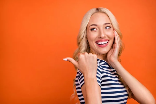 Profile side view portrait of attractive cheerful amazed girl demonstrating copy space ad look isolated over bright orange color background — Stock Photo, Image