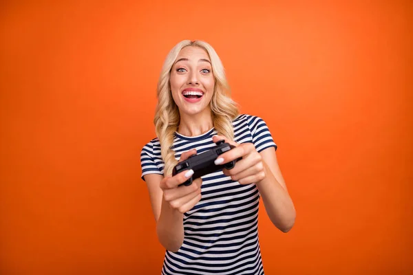 Portret van aantrekkelijke verslaafde vrolijke meisje spelen spel plezier tijdverdrijf geïsoleerd over helder oranje kleur achtergrond — Stockfoto